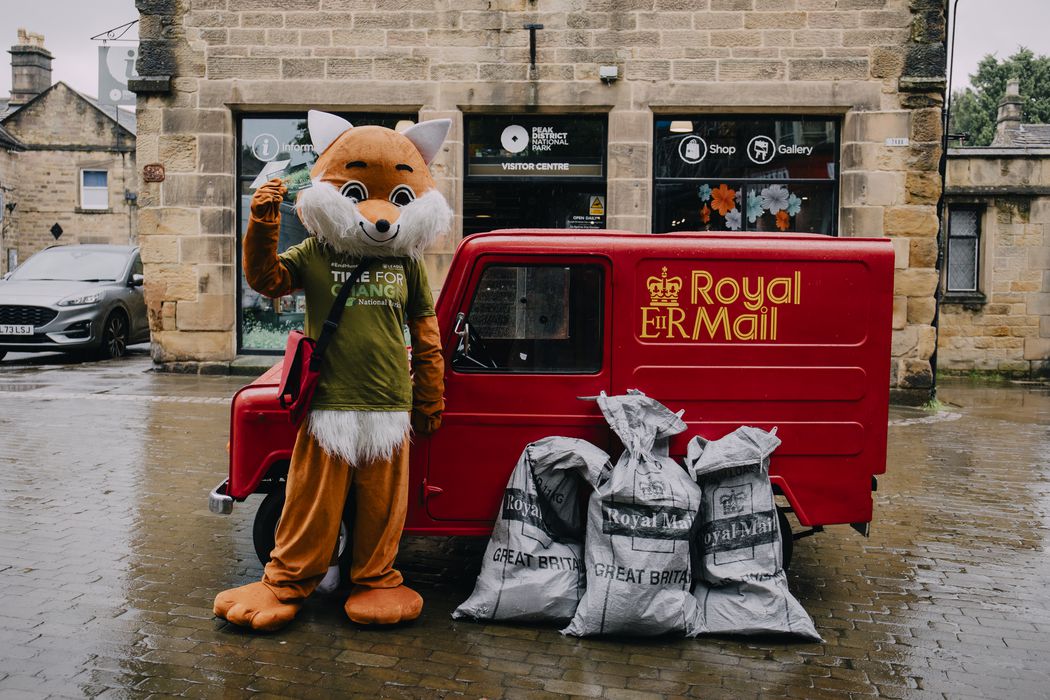 A campaigner in a fox costume with Postman Pat van & mail sacks
